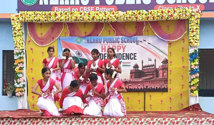 Girls in red and white sarees finish a folk dance