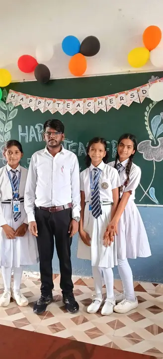 Students with their class teacher in front of a decorated blackboard