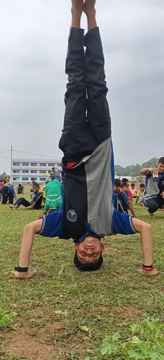 A student holds a headstand on International Yoga Day