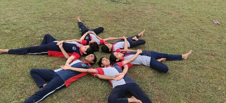 Students form a star on the grass on International Yoga Day